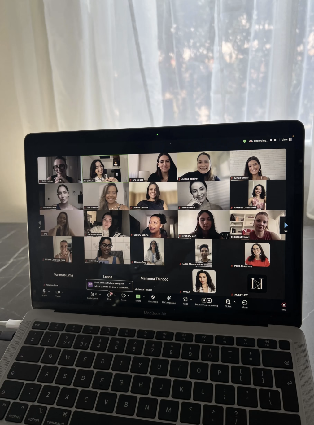 Foto real de um notebook exibindo uma chamada de vídeo da imersão com várias participantes no Zoom